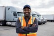 © Meow Creations - Smiling african american truck driver standing with arms crossed in front of white semi trucks
