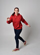 © faestock - full length figure of female model wearing  basic contemporary casual clothing, red hoodie jumper, skinny jeans, sneakers. walking action pose, isolated white studio background.