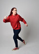 © faestock - full length figure of female model wearing  basic contemporary casual clothing, red hoodie jumper, skinny jeans, sneakers. walking action pose, isolated white studio background.