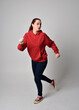 © faestock - full length figure of female model wearing  basic contemporary casual clothing, red hoodie jumper, skinny jeans, sneakers. walking action pose, isolated white studio background.