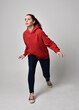 © faestock - full length figure of female model wearing  basic contemporary casual clothing, red hoodie jumper, skinny jeans, sneakers. walking action pose, isolated white studio background.
