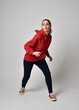 © faestock - full length figure of female model wearing  basic contemporary casual clothing, red hoodie jumper, skinny jeans, sneakers. walking action pose, isolated white studio background.