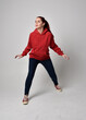© faestock - full length figure of female model wearing  basic contemporary casual clothing, red hoodie jumper, skinny jeans, sneakers. walking action pose, isolated white studio background.