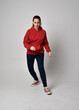© faestock - full length figure of female model wearing  basic contemporary casual clothing, red hoodie jumper, skinny jeans, sneakers. walking action pose, isolated white studio background.