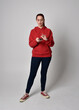 © faestock - full length figure of female model wearing  basic contemporary casual clothing, red hoodie jumper, skinny jeans, sneakers. standing walking pose holding cell phone mobile,  isolated white studio backg