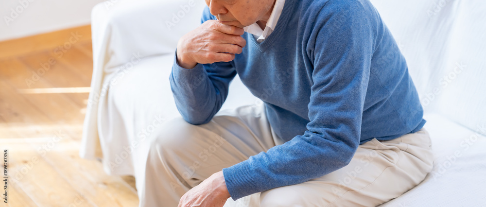 頭を抱えるシニア男性