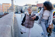 © Iryna - Laughing teenage girl walking with confident smiling woman on city bridge