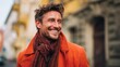 © mila103 - Smiling caucasian male adult in orange coat and scarf outdoors.