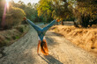 © Natalie Wheeler - Teenage girl doing a cartwheel in the woods