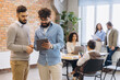 © anatoliycherkas - Diverse startup professionals collaborating and discussing business strategy using a digital tablet in a modern office