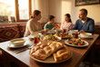 © hasbisahin - Selective focus on fresh ramadan pita bread on a dinner table with a happy Turkish family eating iftar meal in the background