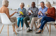 © Prostock-studio - Multiracial group of cheerful elderly men and women in casual sitting on chairs in front of senior coach, taking notes, having educational class at retreat center or nursing home