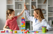 © Prostock-studio - Cute Little Girl Giving High Five To Child Development Specialist During Meeting In Office, Smiling Therapist Lady Greeting Happy Kid With Progress, Celebrating Successful Therapy