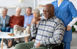 © Prostock-studio - Disabled african american senior man in wheelchair holding nurse hand, looking at copy space and smiling, thanking for support, life in nursing home for elderly people concept