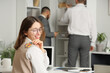 © Pixel-Shot - Young businesswoman with paper fish on her back in office. April Fools' Day celebration