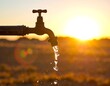 © Wera - Outdoor faucet with water flowing against the setting sun