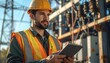© Fachri - Electrician Worker Man In Hard Hat And Safety Vest Holding Tablet At Power Station.