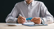 © sorapop - Person holding auto model prepares to sign car contract loan document for finance purchase insurance calculating dealership lease sale terms at desk