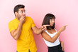 © luismolinero - Young couple isolated on pink background pointing finger to the side with a surprised face