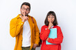 © luismolinero - Young student couple isolated on white background showing a sign of silence gesture putting finger in mouth