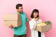 © luismolinero - young beauty couple moving in new home among boxes isolated on pink background presenting an idea while looking smiling towards