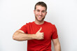 © luismolinero - Young caucasian man isolated on white background giving a thumbs up gesture