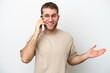 © luismolinero - Young caucasian man isolated on white background keeping a conversation with the mobile phone with someone