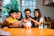 © StockImageFactory - Parents and children dropping coins into piggy bank while learning money values at home