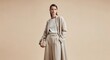 © Hungarian - Fashionable woman presents elegant monochrome outerwear and trousers against a muted background