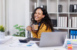 © David - Beautiful African American businesswoman working with documents and paper cup of hot coffee at table in office