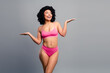 © deagreez - Young confident woman in pink bikini smiles with open arms in a friendly studio lifestyle shot