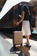 © Parichat - Woman traveling with luggage waiting at train station platform