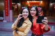 © Parichat - Asian women friends taking selfie at temple