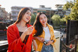 © Parichat - Asian women friends traveling and sightseeing in city