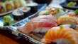 © zaras - A close-up shot of a beautifully arranged plate of fresh sushi and sashimi, featuring salmon, tuna, and various rolls, served in a Japanese restaurant.