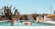 © PintoArt - Family enjoying summer vacation splashing in swimming pool