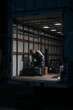 © olegganko - Worker Organizes Tools Inside a Delivery Truck During Nighttime Hours in an Urban Area