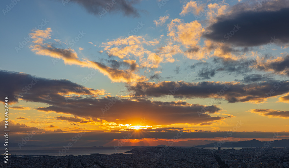 Athens (Greece) at sunset. The city skyline at sunset with dramatic skies and mountains