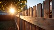 © photoplotnikov - Sunlit wooden fence with golden sun rays and shadows in a peaceful backyard setting during late afternoon