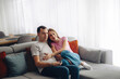 © verona_studio - Couple spends time together on a couch while relaxing in their home during morning hours