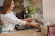 © verona_studio - Woman fills glass with water in modern kitchen in daylight