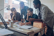 © Geber86 - Young creative team collaborating at drafting table in modern studio