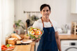 © Kawee - Portrait of Asian man cooking green healthy salad in kitchen at home.