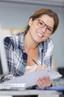 © auremar - smiling woman sitting at desk in modern office