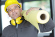 © auremar - man is safety hat is carrying insulating roll