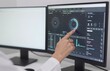 © Generative AI - Analyzing Data on Dual Monitors: A Close-Up of a Hand Pointing to a Modern Interface