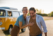 © Westend61 - Happy couple doing a road trip with a camper, embracing on the road