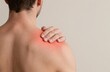 © Generative AI - Man experiencing shoulder pain, discomfort with hand touching shoulder, highlighted red area on the shoulder.