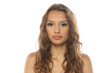 © vladimirfloyd - Studio shot of a young woman with long wavy brown hair wearing makeup, front view portrait, on a white background