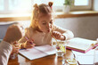 © Lustre Art Group  - Little girl drinking water with lemon while drawing at table. Concept of healthy hydration, daily water habits, child focus, home education routine, calm family lifestyle, and natural refreshment.